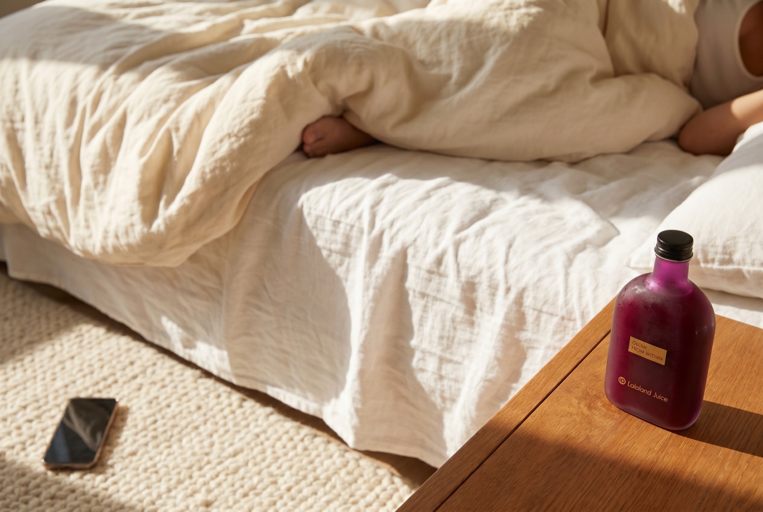 A sunlit unmade bed on a slow Sunday morning, a Lalaland bottle on the nightstand